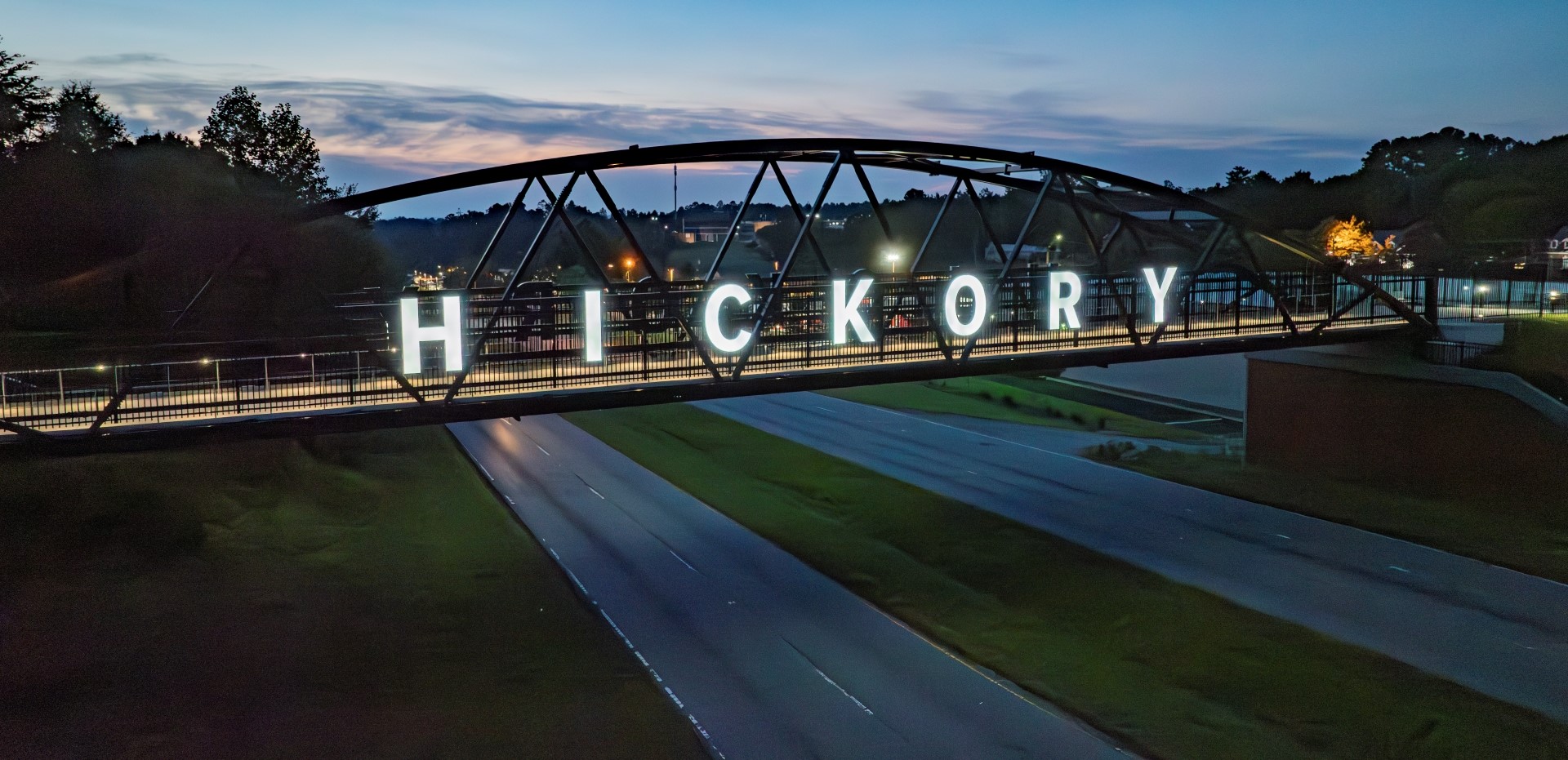 picture of the pedestrian bridge at sunset with the Hickory sign lit up